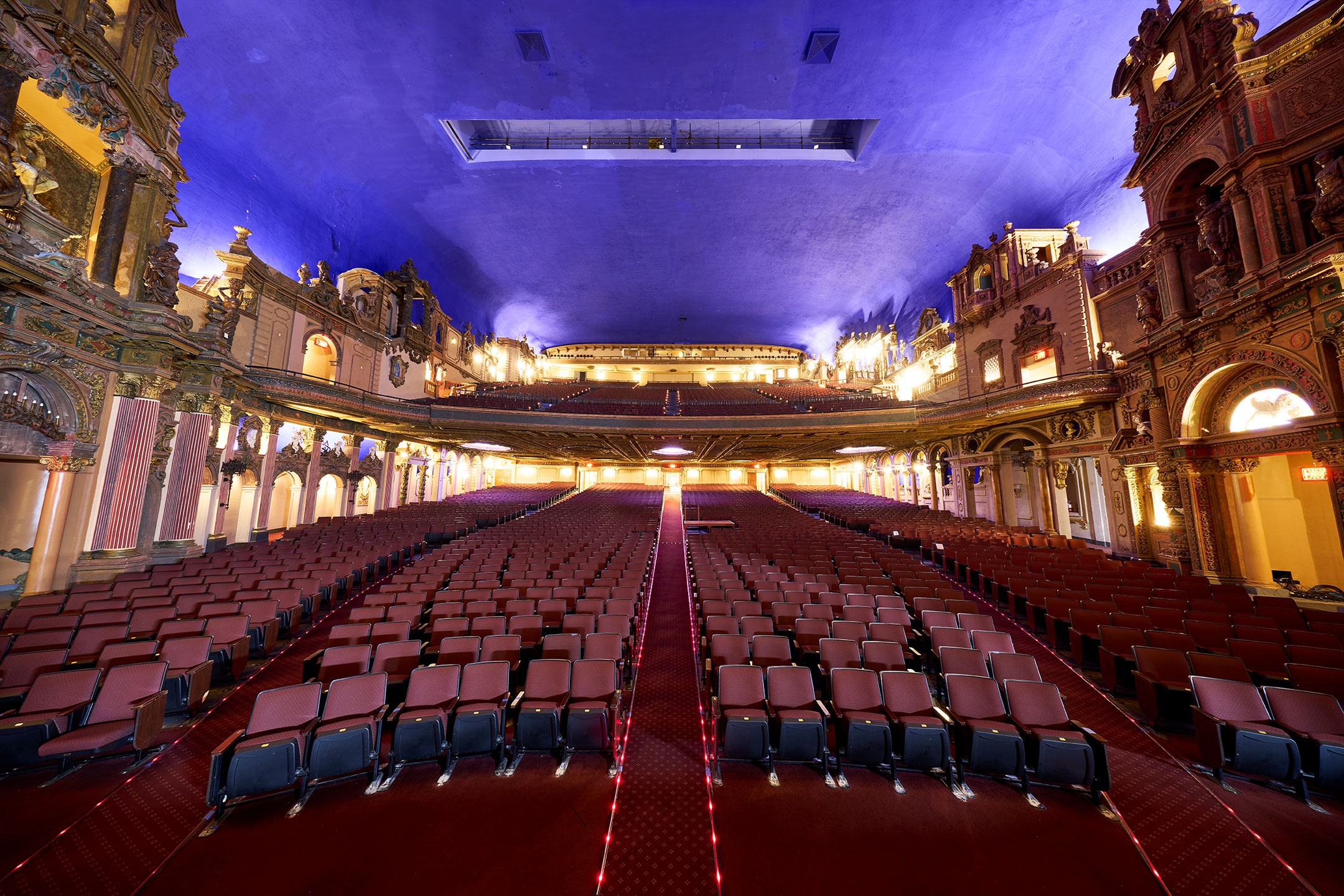 The central aisle leads through rows of seats toward the balconies.