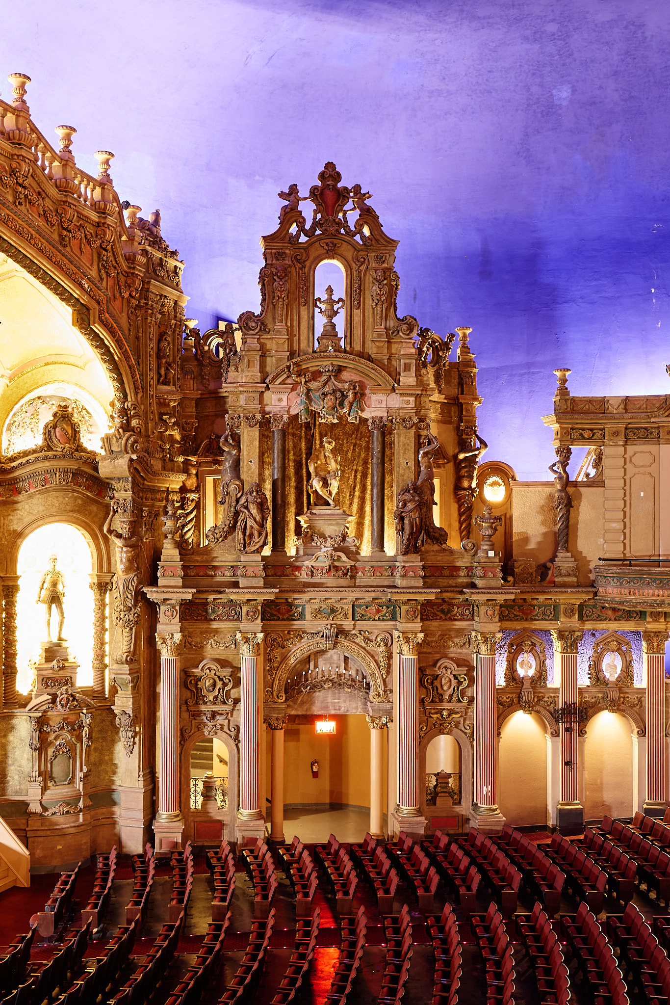 Gilded architectural details rise above the auditorium’s red seats.